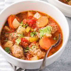 Albondigas soup scooped into white bowl.