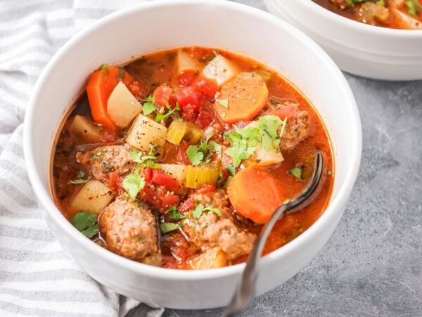 Albondigas soup scooped into white bowl.