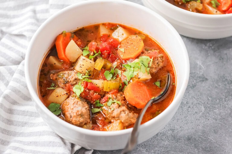 Albondigas soup scooped into white bowl.