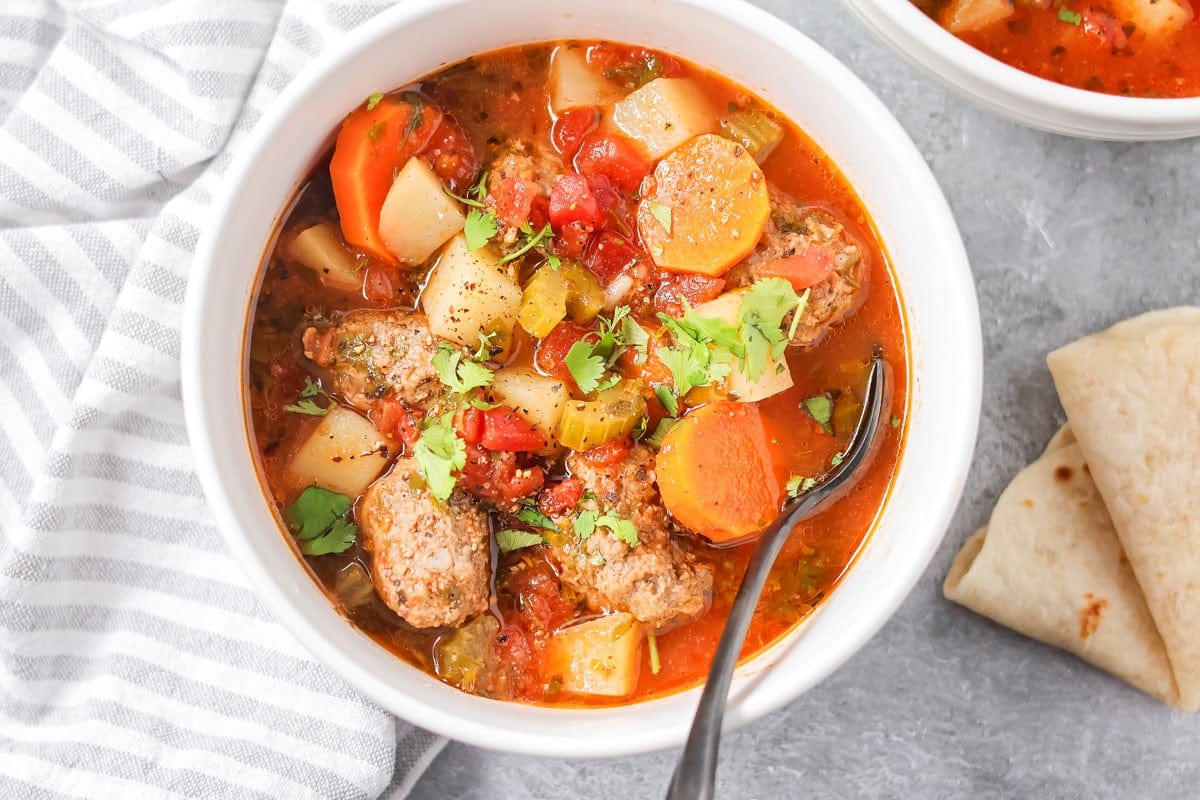 Close up image of Albondigas soup recipe in white bowl.