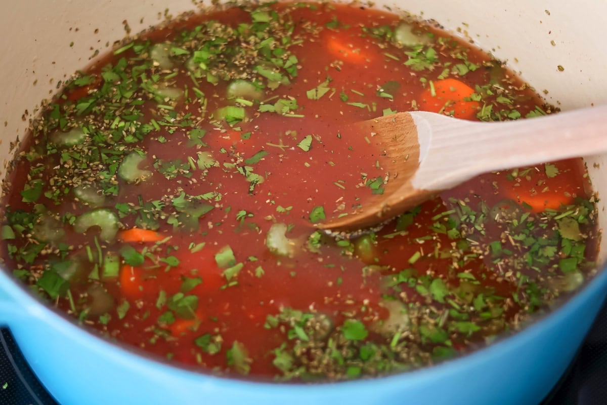 Veggies and spices added to albondigas soup recipe.