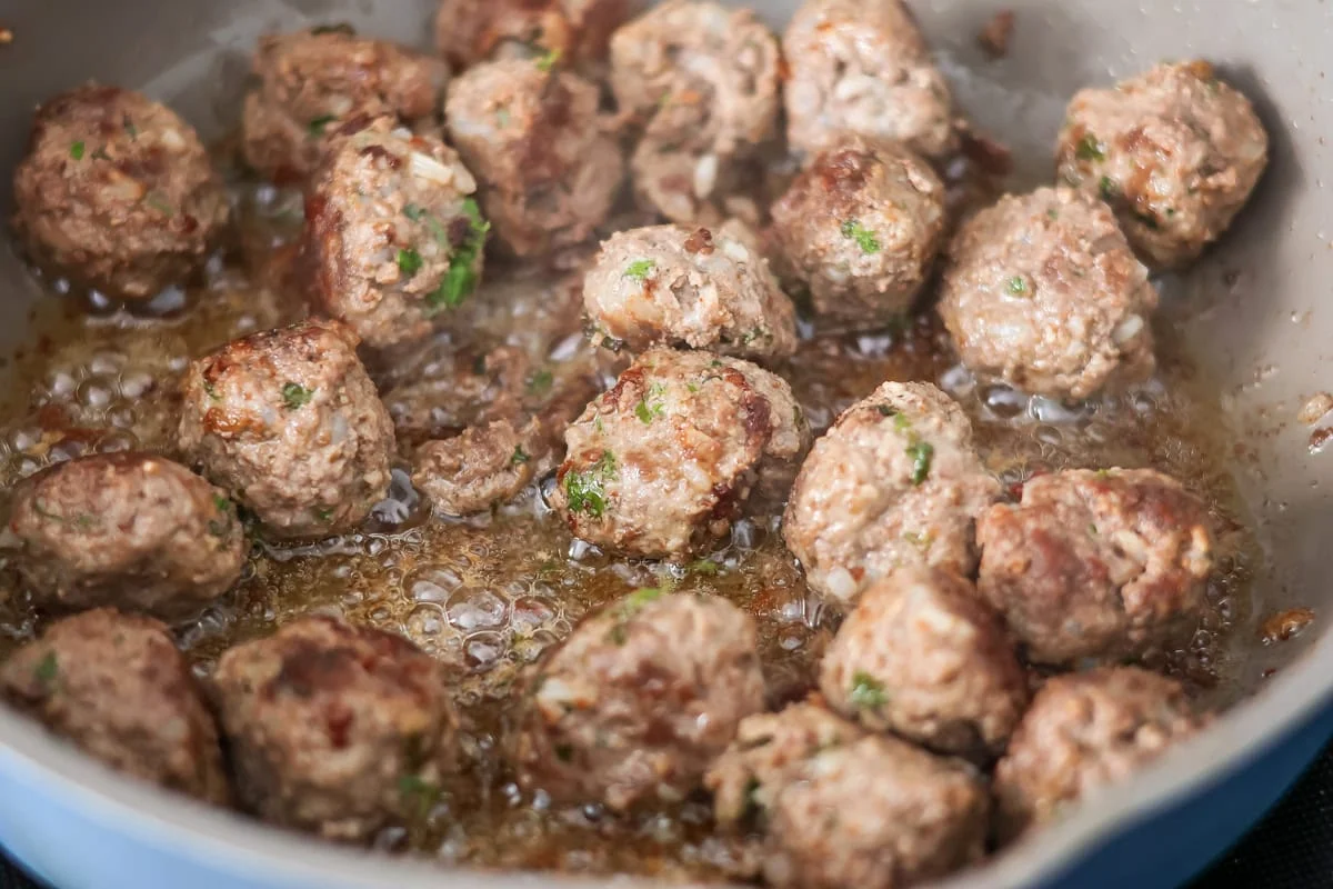 Cooked meatballs in skillet.