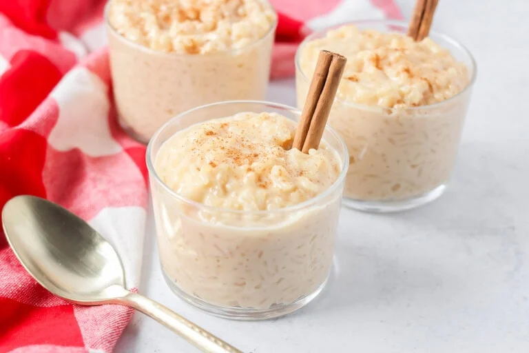 Homemade arroz con leche recipe in glass cups with cinnamon sticks.