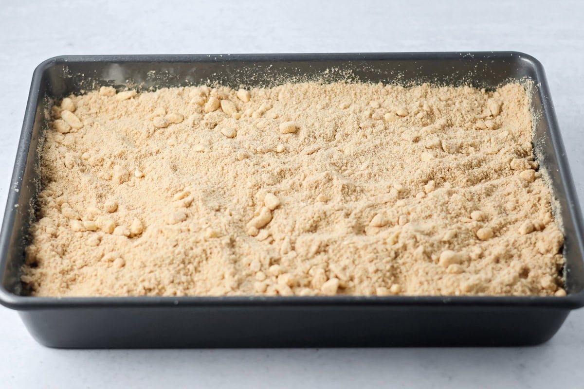 Streusel poured over coffee cake in pan.
