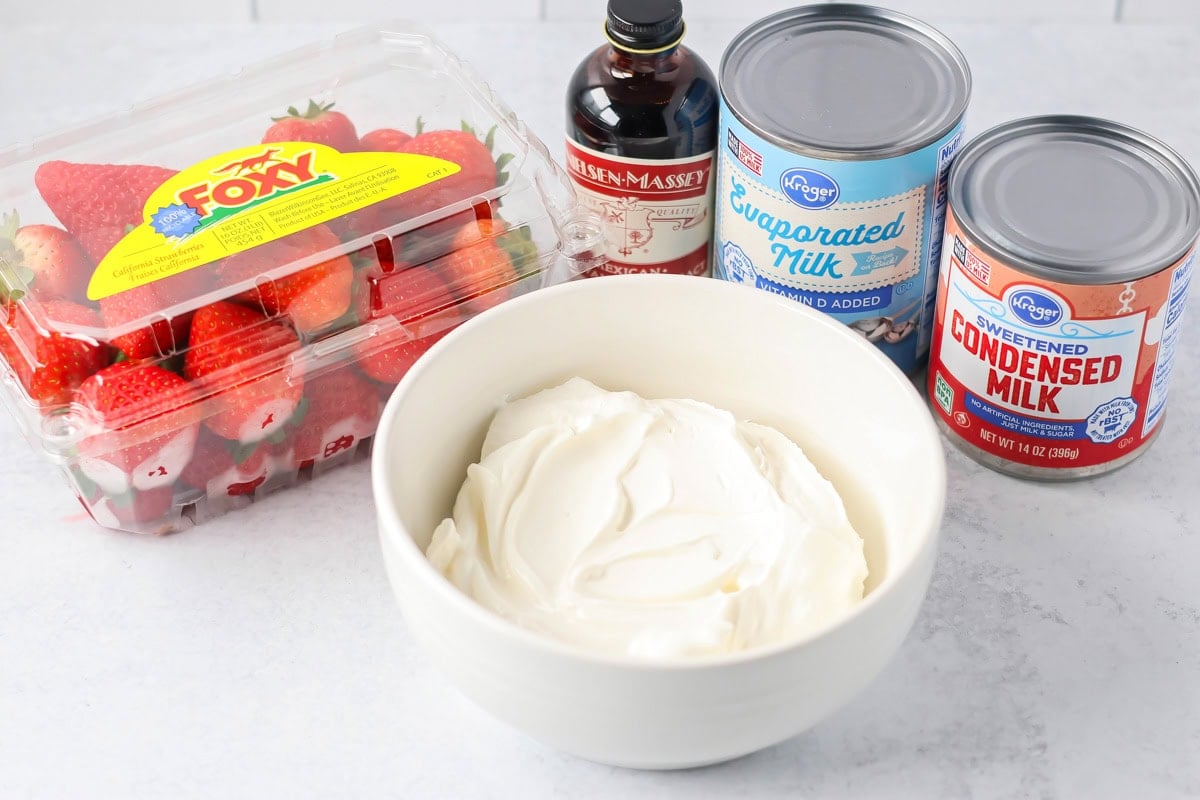 Fresas con Crema mixes strawberries with a silky vanilla cream. This 10-minute, no-bake dessert chills into spoonable perfection. Ingredients to make frescas con crema on a kitchen counter.
