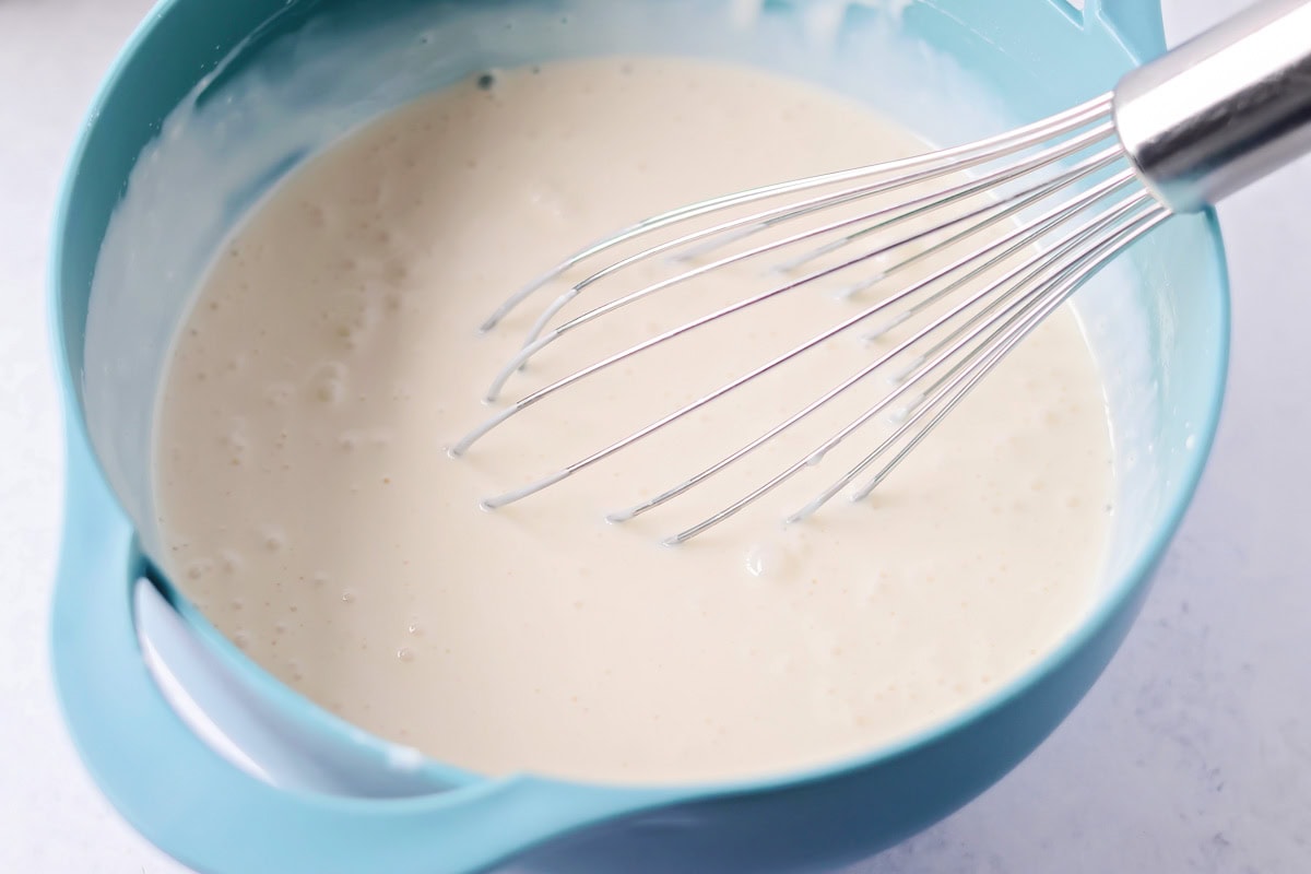 Fresas con Crema mixes strawberries with a silky vanilla cream. This 10-minute, no-bake dessert chills into spoonable perfection. Mixing three milks in a bowl.