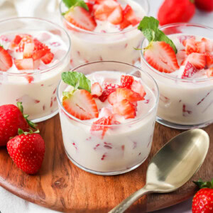 Easy Frescas con Crema served in individual cups topped with fresh strawberries.
