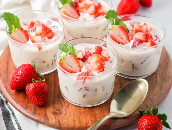 Easy Frescas con Crema served in individual cups topped with fresh strawberries.