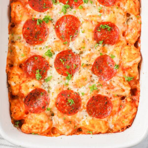Pizza casserole recipe in baking dish with parsley sprinkled on top.