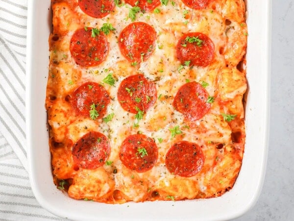 Pizza casserole recipe in baking dish with parsley sprinkled on top.