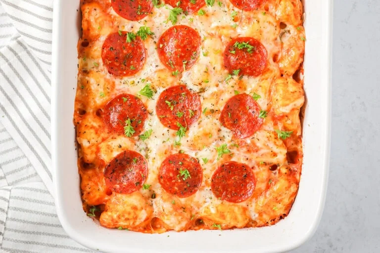 Pizza casserole recipe in baking dish with parsley sprinkled on top.