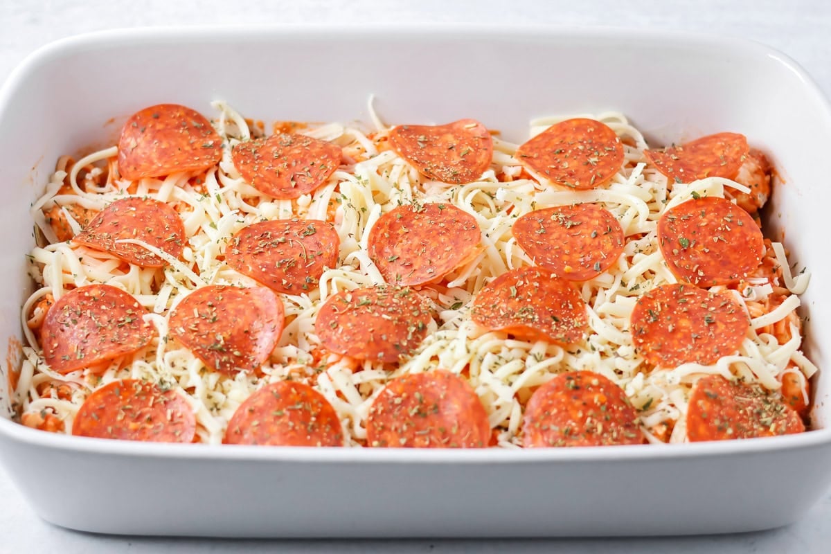Pizza casserole in baking dish with toppings on top.