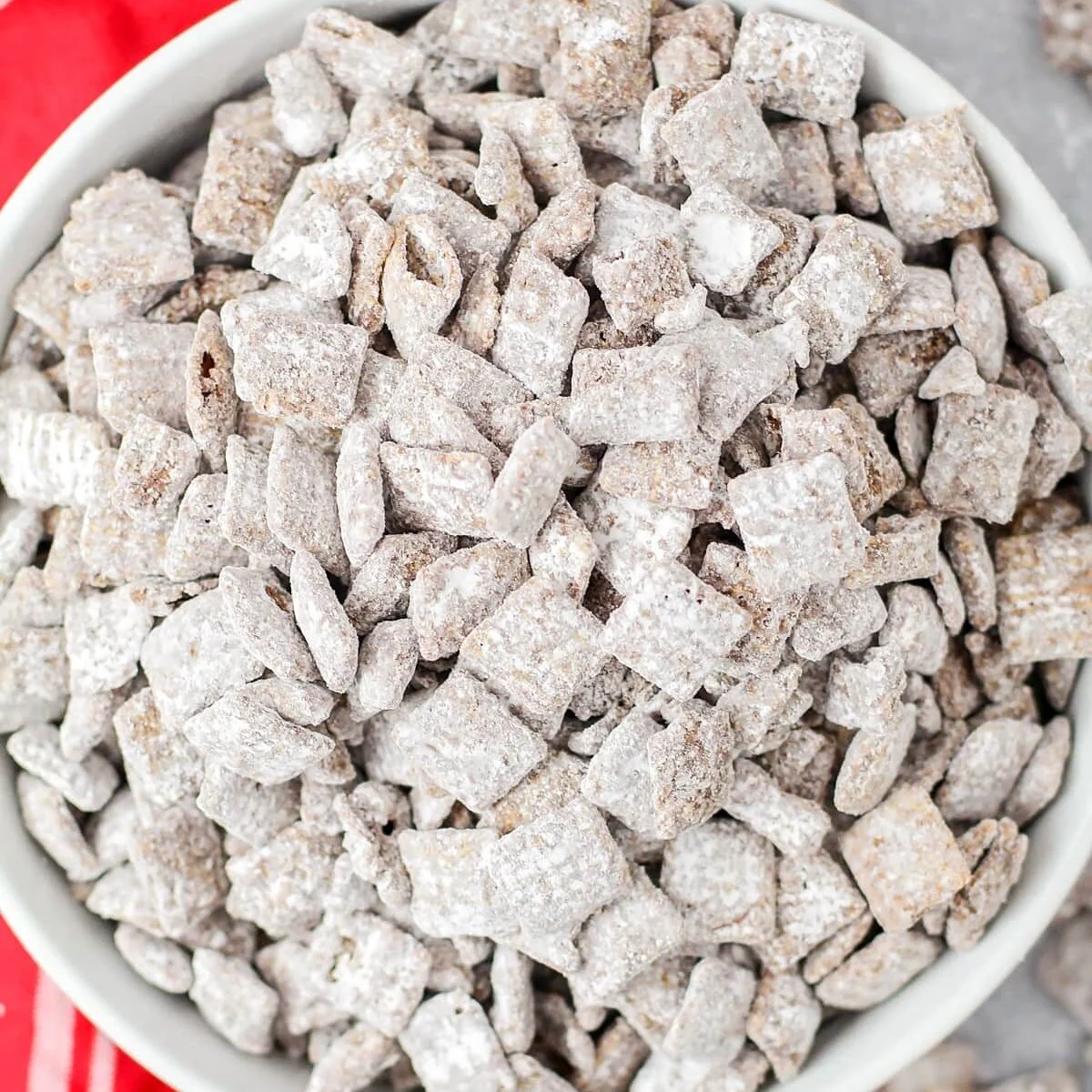 Homemade Puppy chow recipe made and put in white glass bowl.