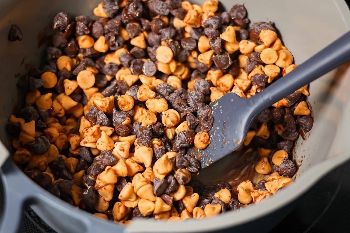 These scotcharoo cookies with crispy cereal, peanut butter, and a chocolate butterscotch topping are perfect for parties and evenings at home. Chocolate and butterscotch chip in a saucepan.