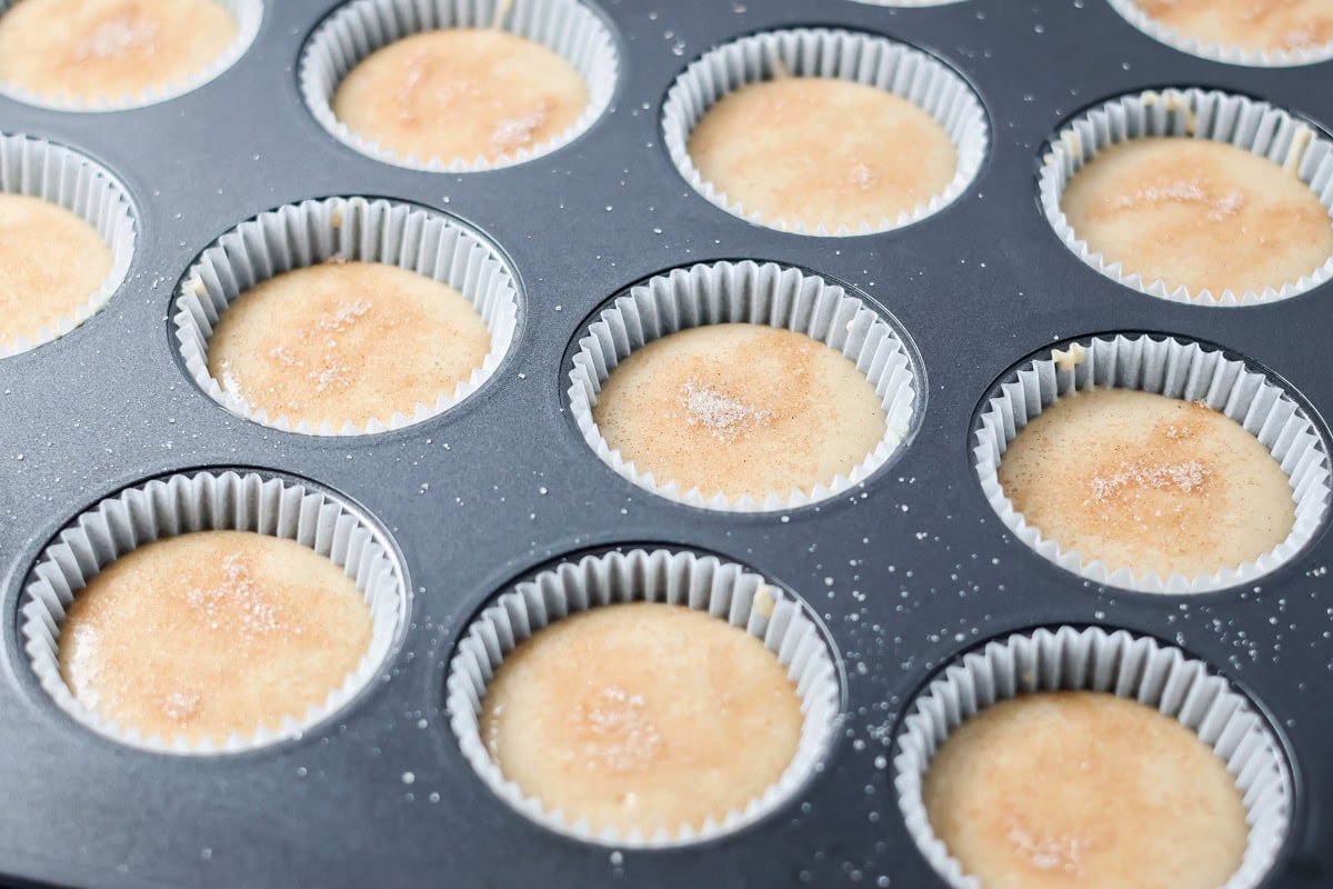 Soft cinnamon honey cupcakes with a crackly sugar top and creamy frosting, easy to make and perfect for parties or cozy weeknights. Sprinkling cinnamon and sugar over the batter.