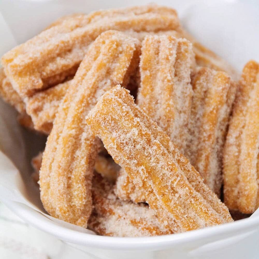 This churro recipe is a family favorite! It's fried to perfection and covered in cinnamon and sugar making it incredibly delicious. Homemade churro recipe close up image.