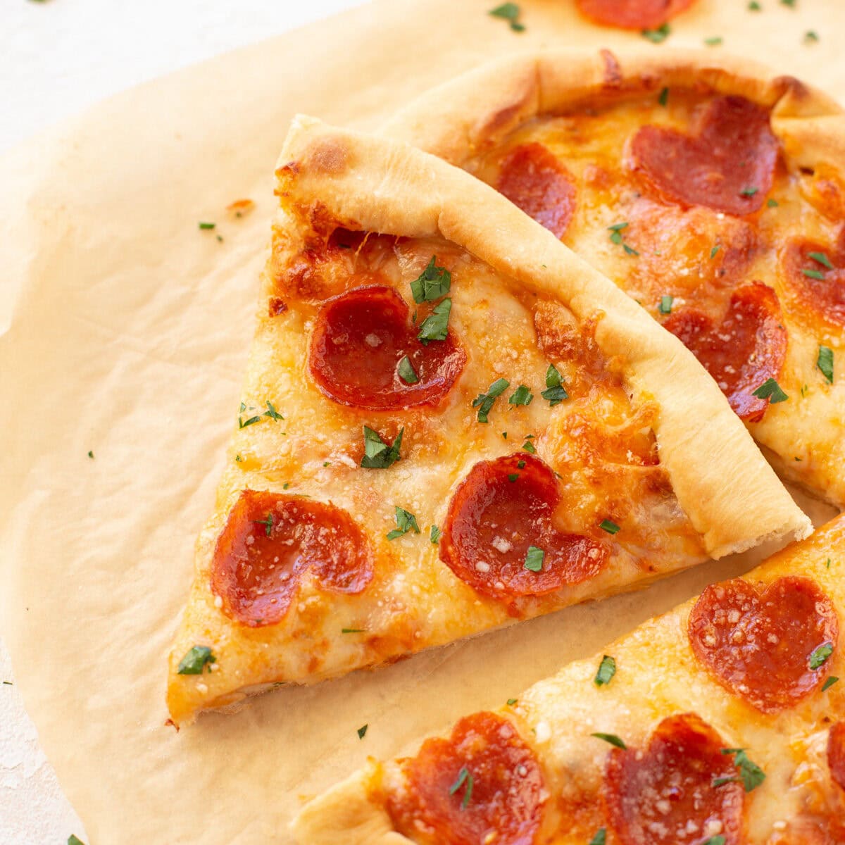Heart shaped pizza slice on baking sheet.