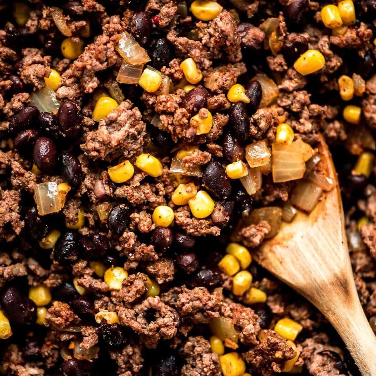 A simple twist on a favorite, our layered beef enchilada casserole is prepped in 15 minutes for a comforting classic, perfect for weeknights! Meat mixture for enchilada casserole close up image.