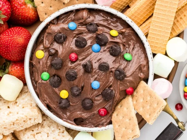 Brownie batter dip recipe in bowl with dippers all around;.
