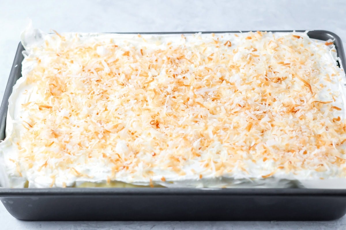 Coconut cream pie bars topped with toasted coconut.
