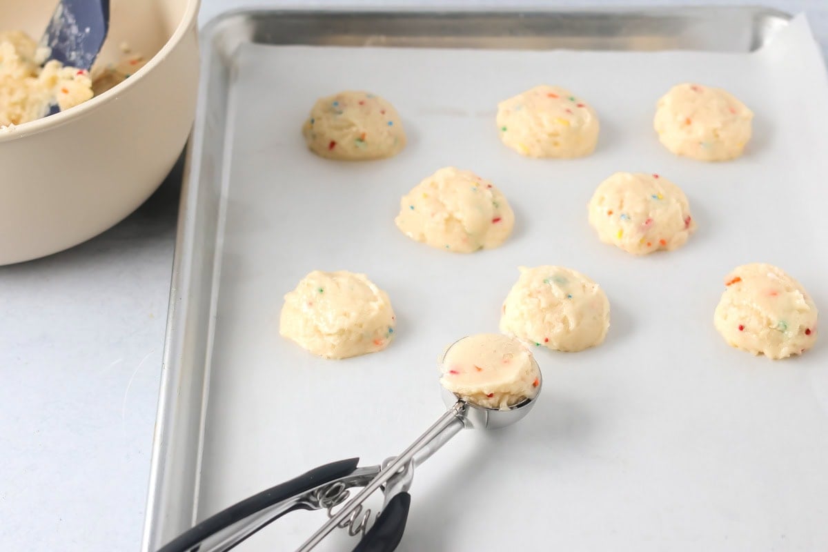 Funfetti cake mix cookies scooped onto baking sheet.