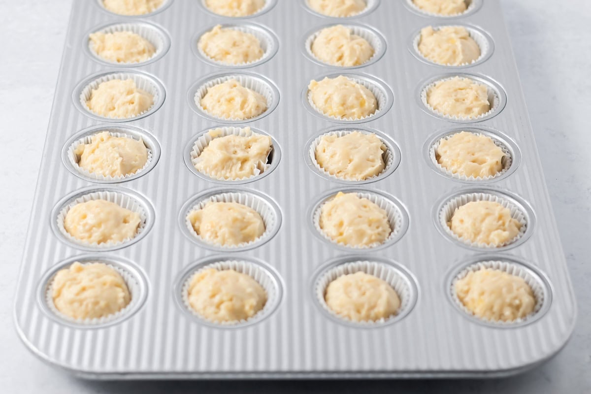 Banana muffin batter spooned into mini muffin pan.