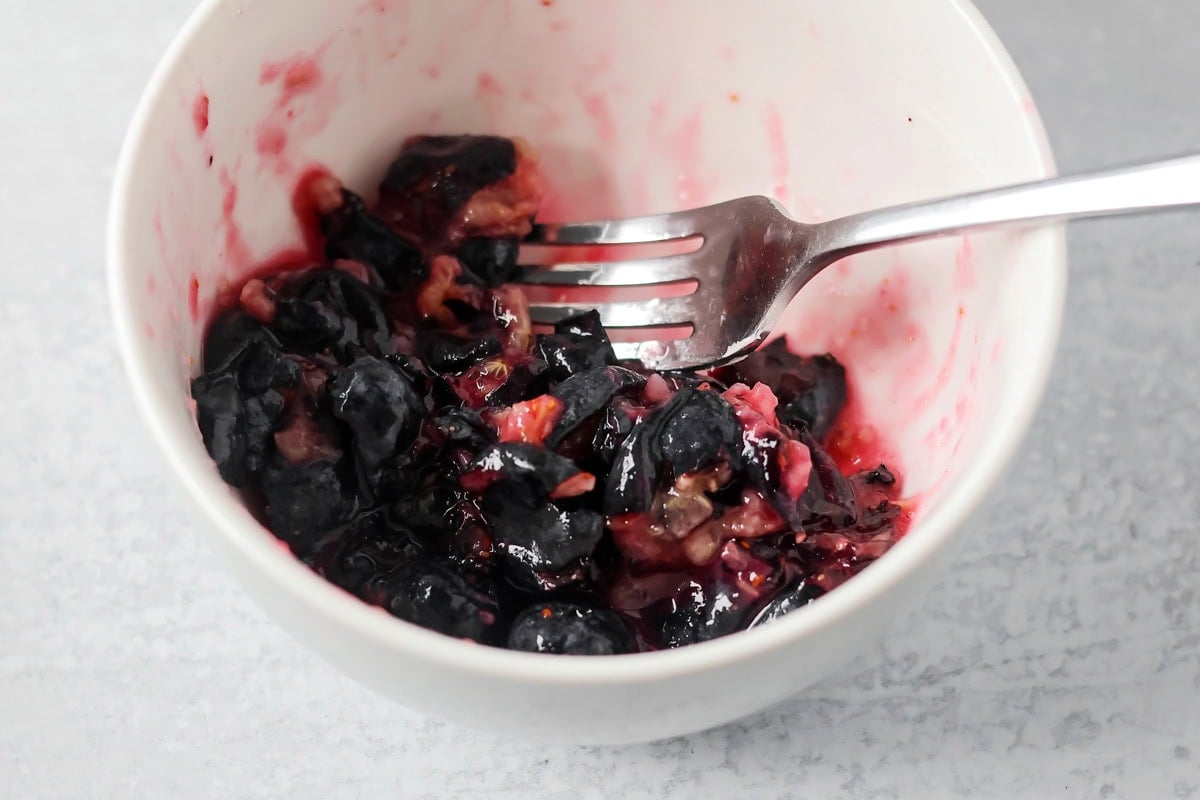 Crushed blueberries in small bowl.