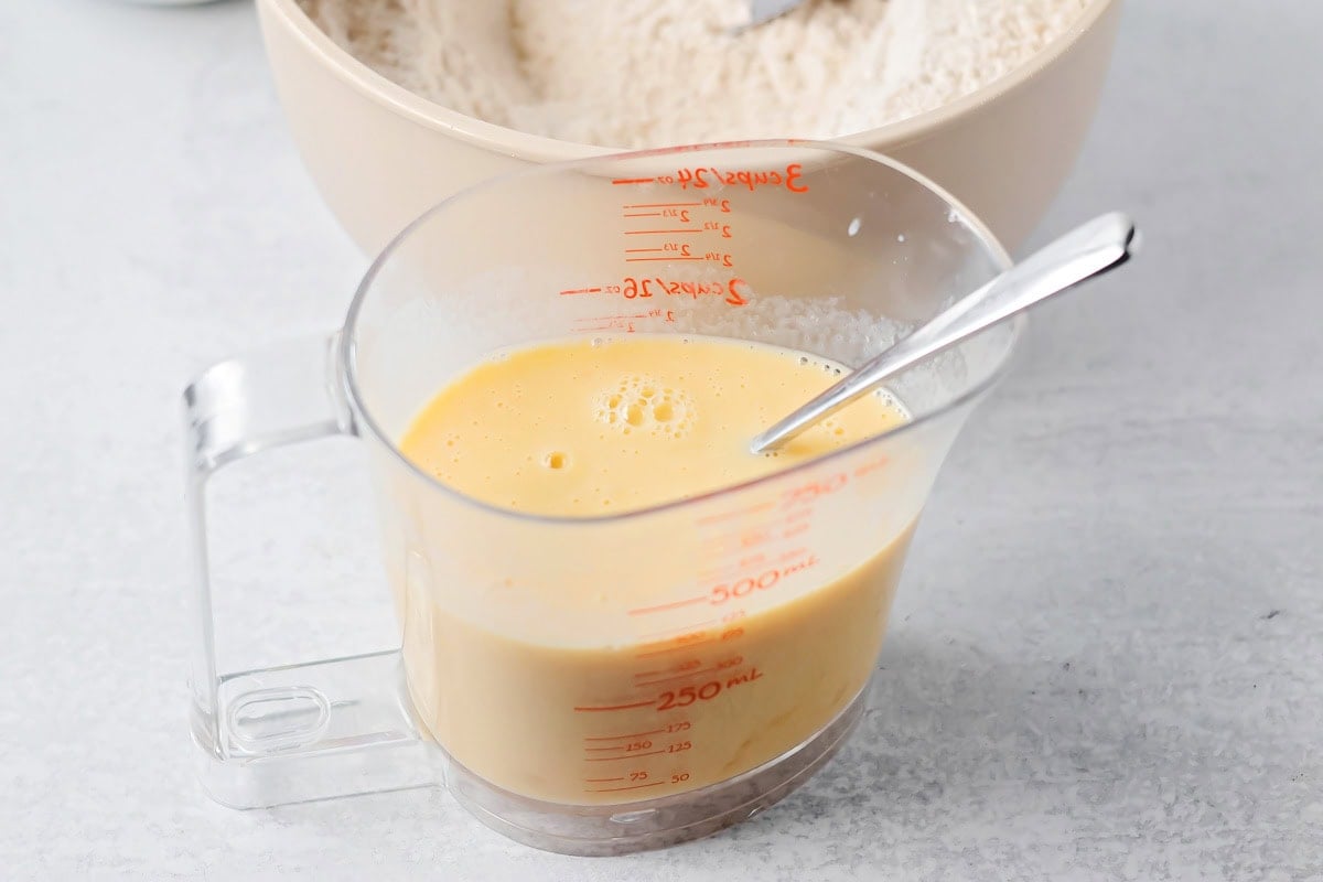 Milk, melted butter, eggs and vanilla mixed together in measuring cup.