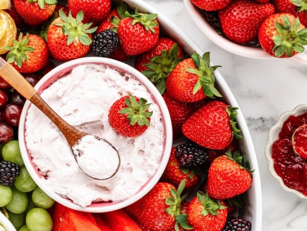 Strawberry fruit dip recipe in bowl with fruit all around.
