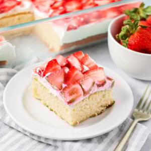 Strawberry shortcake bars cut up on plate with more bars in the background.
