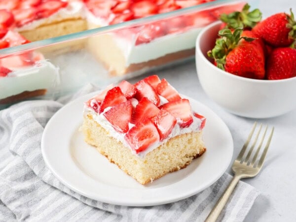 Strawberry shortcake bars cut up on plate with more bars in the background.