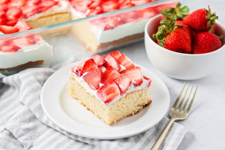 Strawberry shortcake bars cut up on plate with more bars in the background.