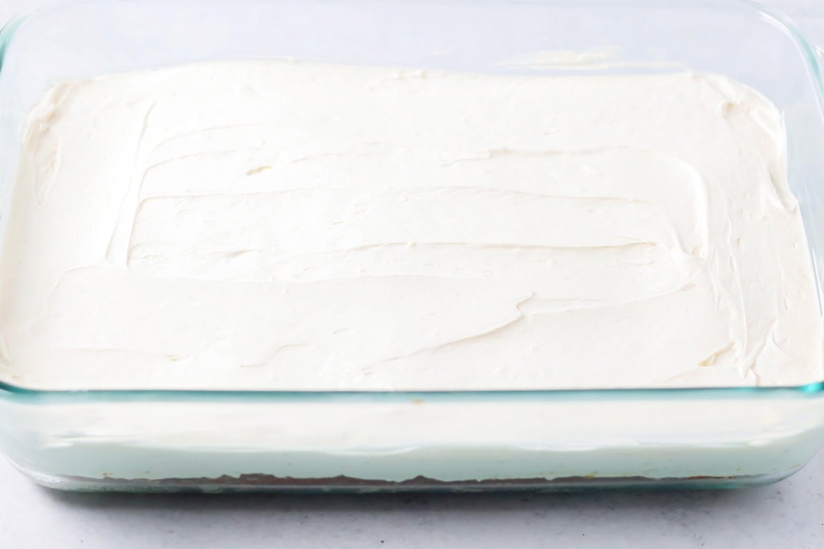 Whipped topping spread over bars in baking dish.