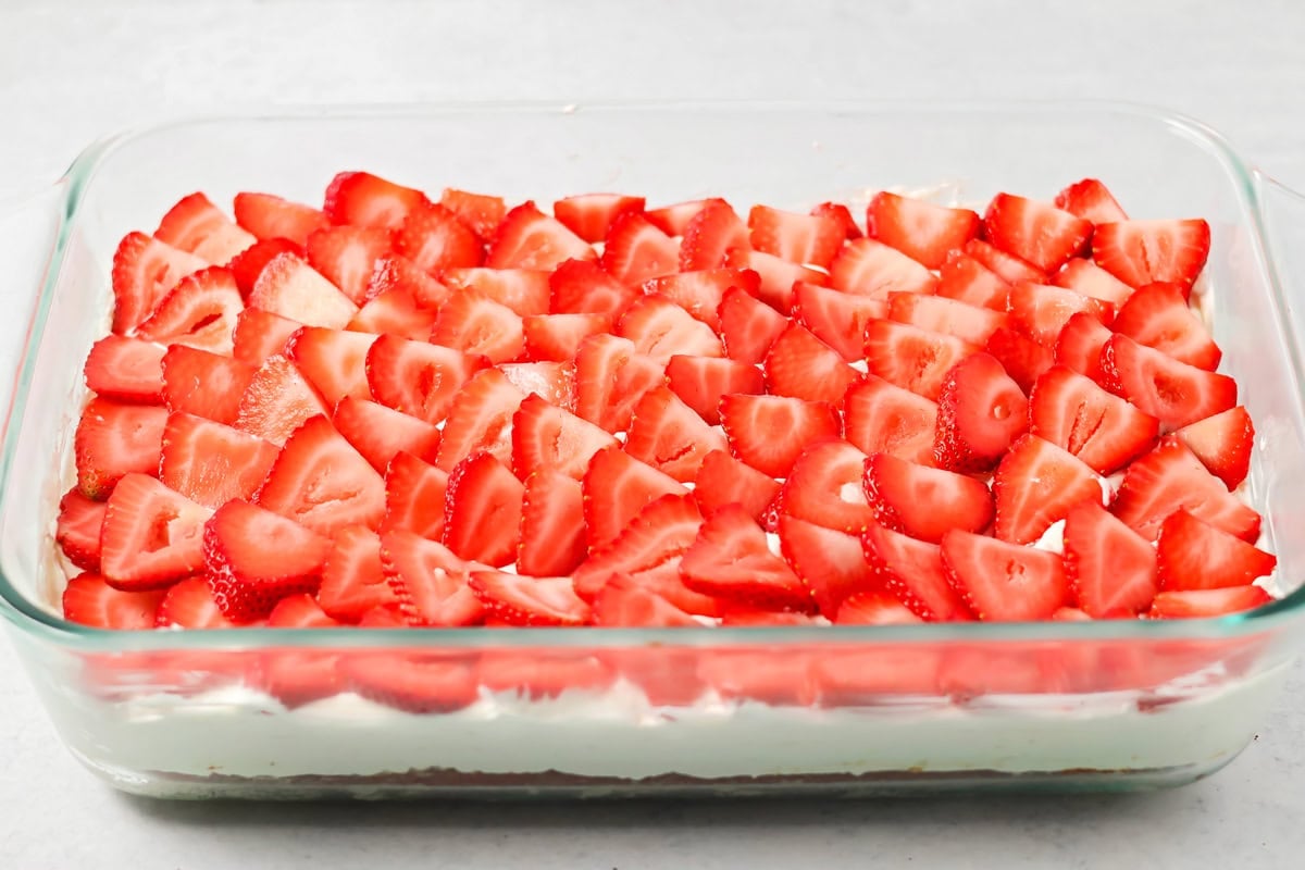 Strawberries topped shortcake bars in baking dish.