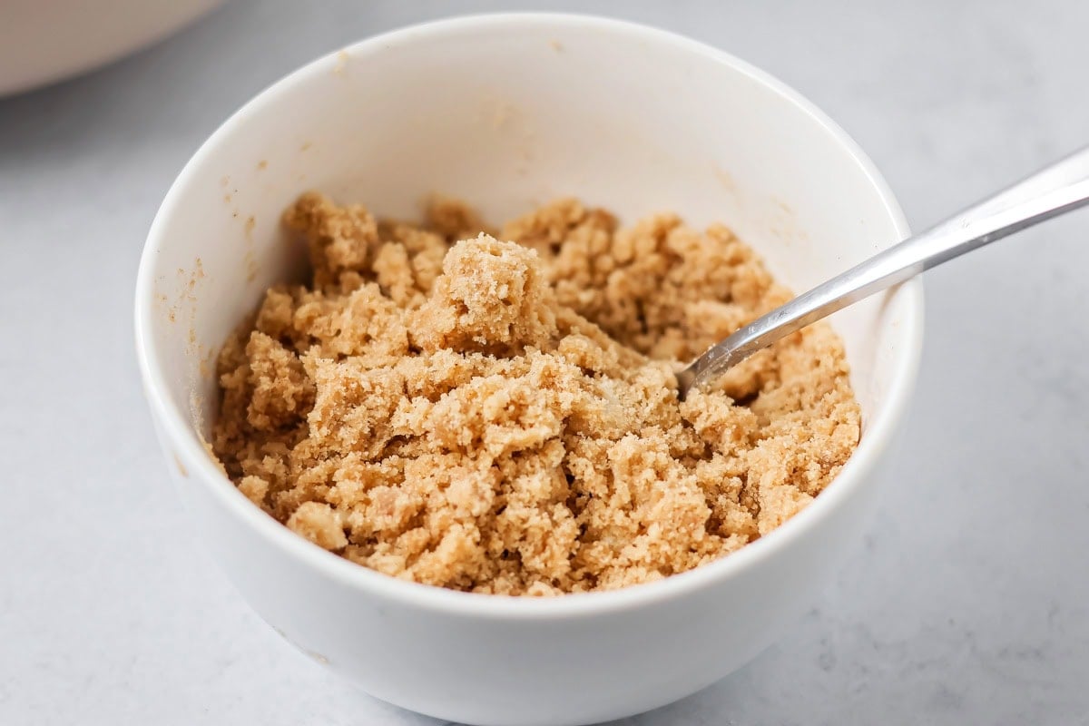 Crumb topping in a white bowl for banana crumb muffins.