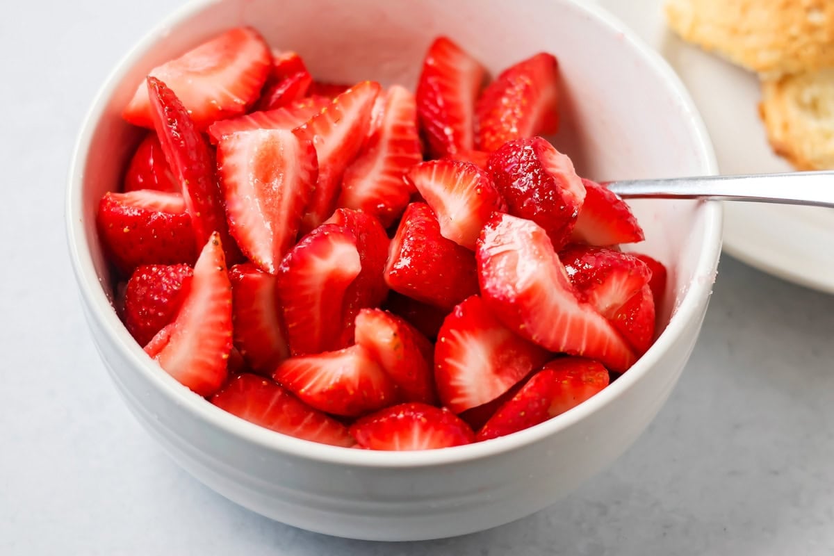Macerating strawberries in a bowl for strawberry shortcake recipe.