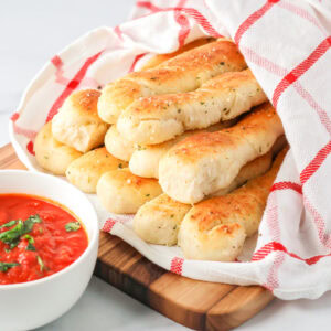 Homemade breadsticks served in a basket.