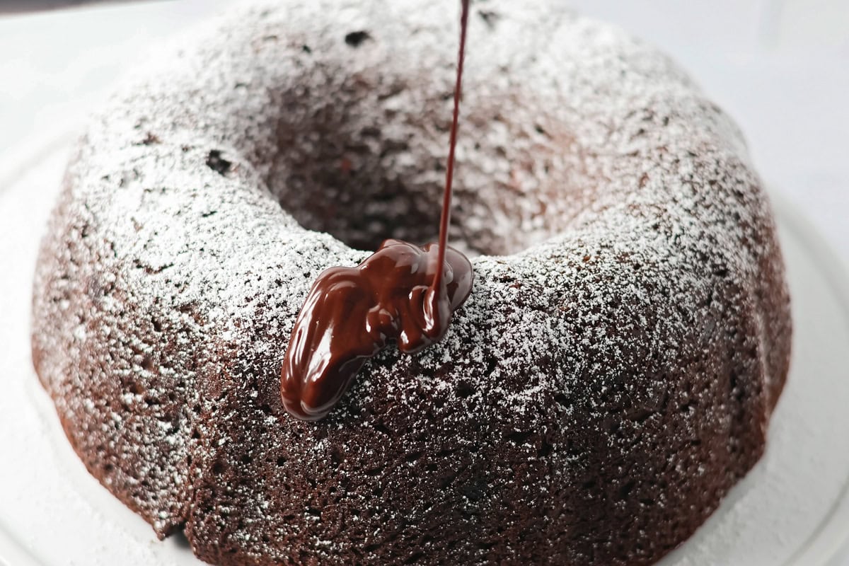 Glaze being poured over brownie cake.