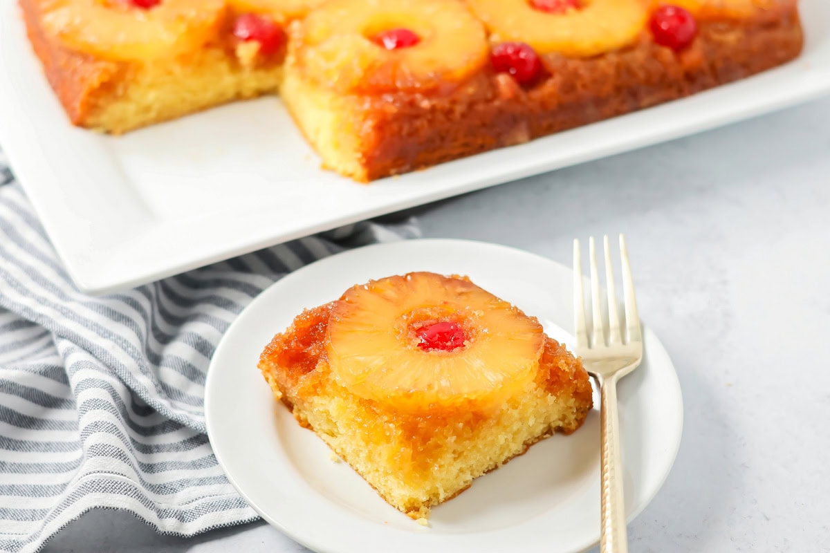 A slice of easy pineapple upside down cake on a white plate.