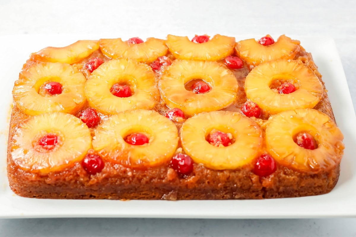 A finished pineapple upside down cake served on a white platter.