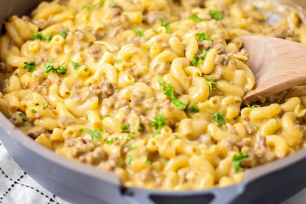 Homemade Hamburger Helper in a pan with a wooden spoon.