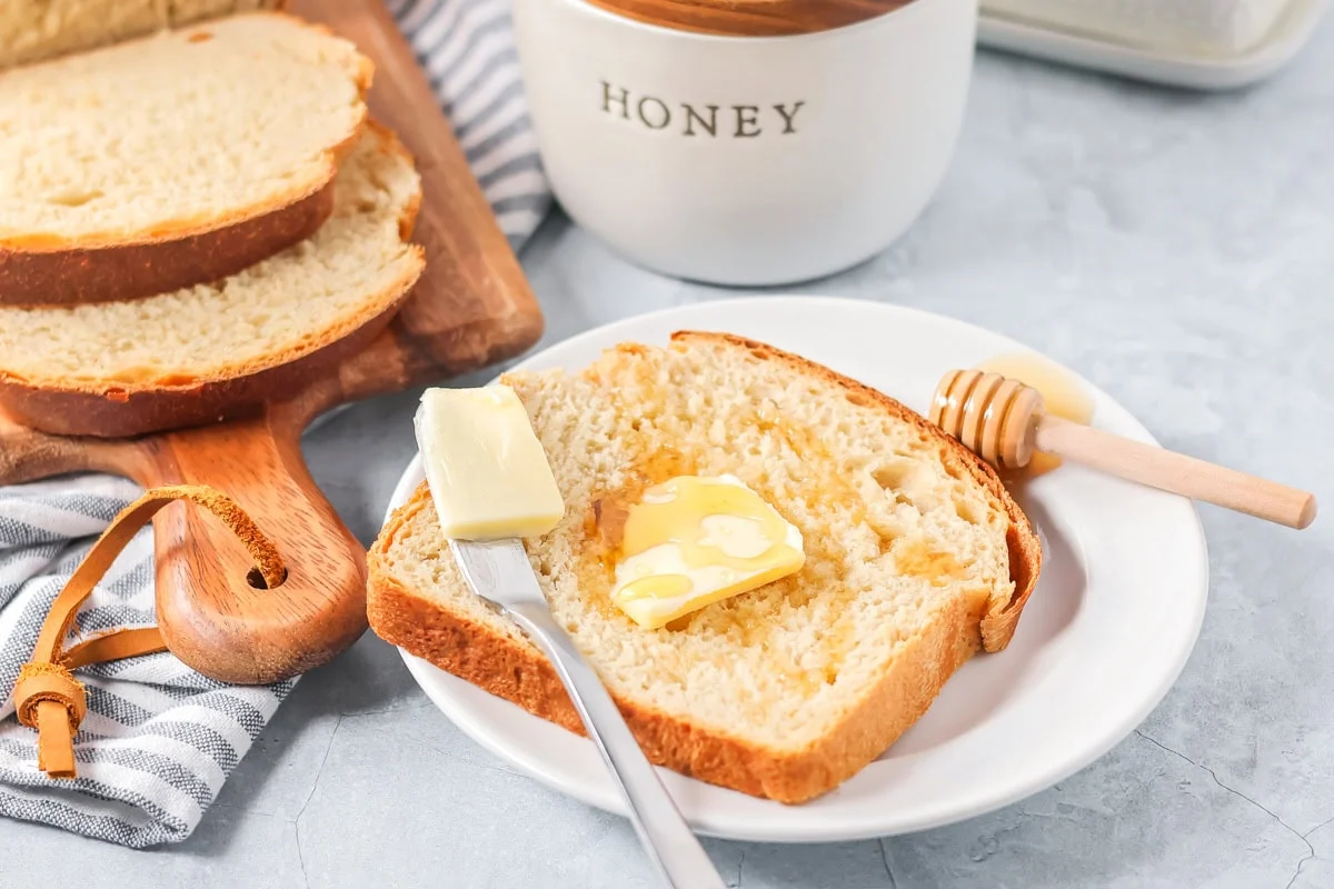 Sliced easy honey bread topped with butter and honey.