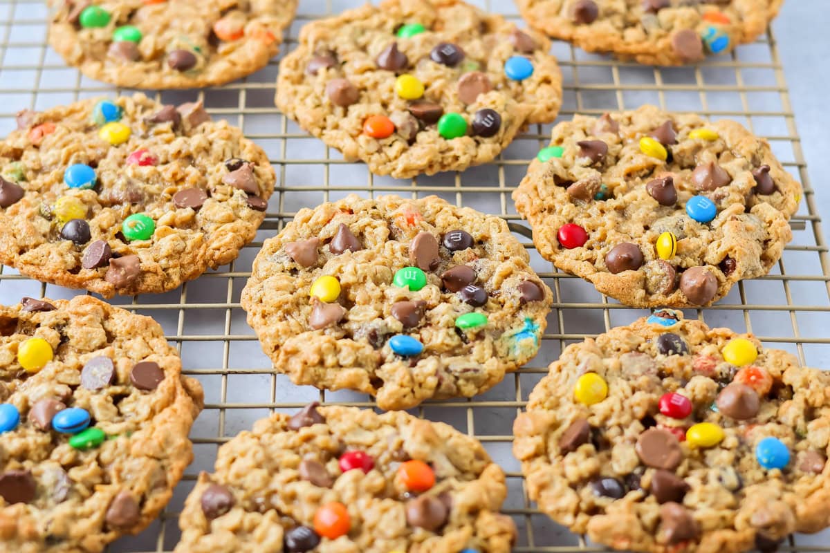 Several monster cookies on a cooling rack.