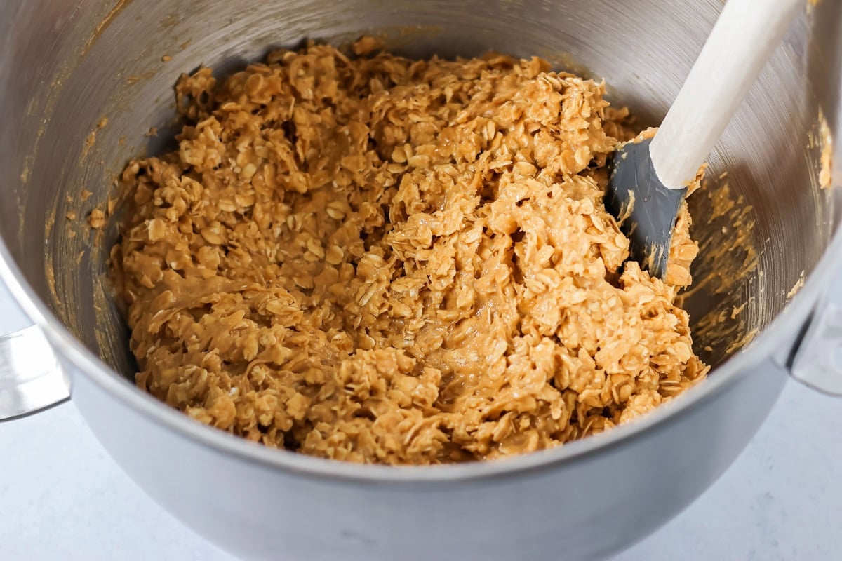 Mixing cookie dough in a metal bowl.