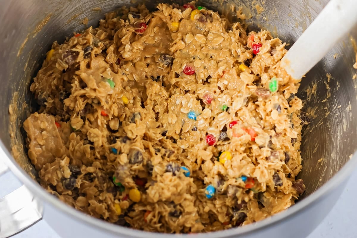 Monster cookie dough in a metal mixing bowl.