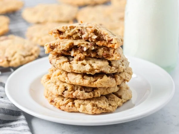 A stack of oatmeal toffee cookies stacked on a white plate.