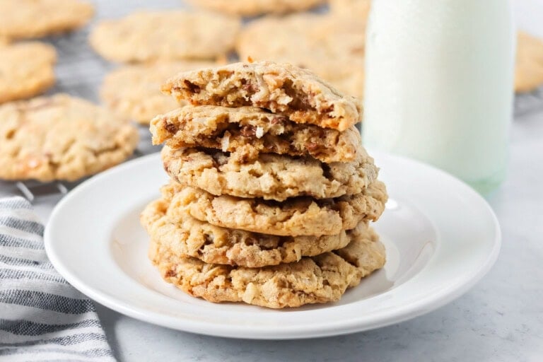 A stack of oatmeal toffee cookies stacked on a white plate.