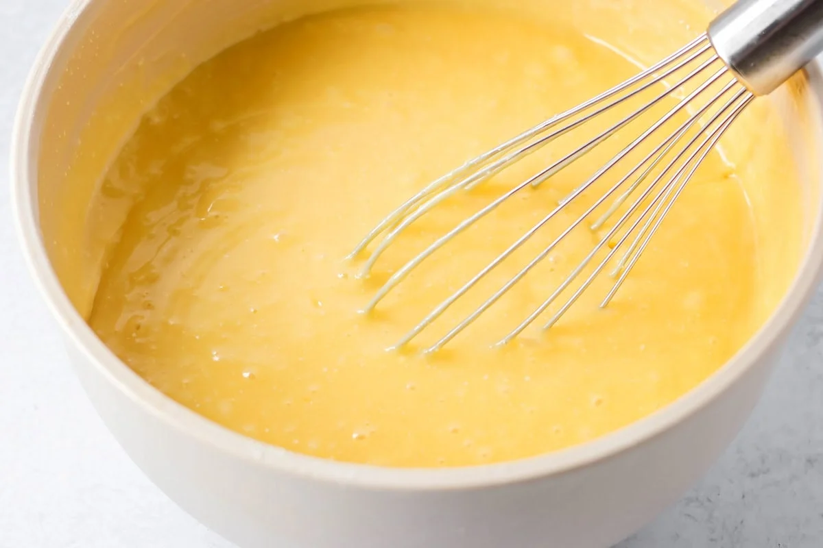 Peaches and cream cake batter in a white bowl.