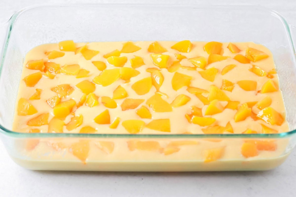 Peach chunks added to the batter of a peach cake.