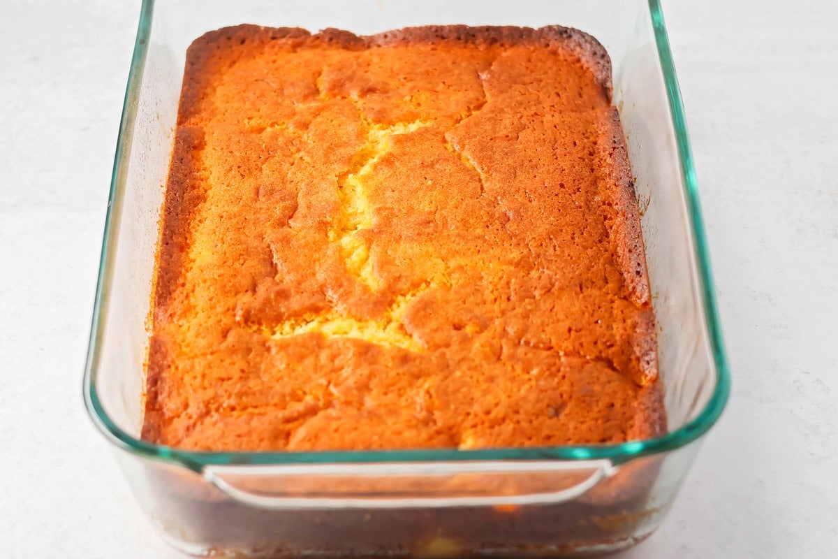 A baked peach cake in a baking dish.